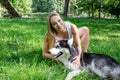 Attractive blonde plays with her dog in the park. Royalty Free Stock Photo