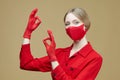 Blonde in red gloves and a mask shows the OK sign. the concept of preventing coronavirus covid 19 Royalty Free Stock Photo