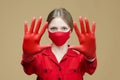 Blonde in red gloves and a mask shows the sign STOP with her hands. the concept of preventing coronavirus covid 19 Royalty Free Stock Photo