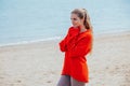 The blonde in the red walks along the beach of the sea coast Royalty Free Stock Photo