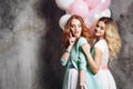 Blonde and redhead. Two young charming girlfriends at the party. Happy and cheerful girl with balloons. Royalty Free Stock Photo