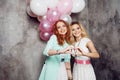 Blonde and redhead. Two young charming girlfriends at the party. Royalty Free Stock Photo