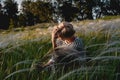 The blonde is resting in the field in the fluffy grass. Unity with nature, travel across the country. Recreation