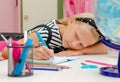 Blonde school girl lying on her hand writng homework. Selective focus. Learning concept Royalty Free Stock Photo