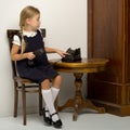 Blonde schoolgirl making phone call. Photo session in the studio Royalty Free Stock Photo
