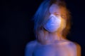 Blonde sensitive young slim woman in white respirator face mask. Royalty Free Stock Photo