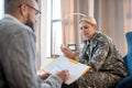 Blonde servicewoman feeling confused while having psychoanalysis