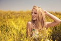 Blonde young beautiful girl in the field yellow flowers Royalty Free Stock Photo