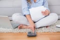 Blonde sitting on carpet using calculator Royalty Free Stock Photo