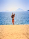 Blonde slim girl in bikini runs from sea on sand laughs Royalty Free Stock Photo