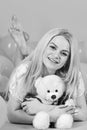 Blonde on smiling face relaxing with teddy bear toy. Birthday girl concept. Woman cute celebrate birthday with balloons