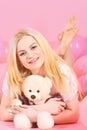 Blonde on smiling face relaxing with teddy bear toy. Birthday girl concept. Woman cute celebrate birthday with balloons