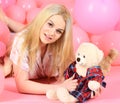 Blonde on smiling face relaxing with teddy bear toy. Woman cute celebrate birthday with balloons. Girl in pajama