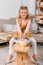 blonde smiling kid making ceramics on pottery wheel Royalty Free Stock Photo