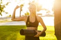 Blonde sports woman in park outdoors showing biceps. Royalty Free Stock Photo