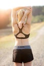 Blonde sporty woman stretches muscles after jogging, running and exercising outdoors in nature Royalty Free Stock Photo