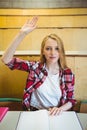 Blonde student raising hand during class