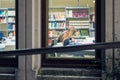 Blonde student reading book in library at night