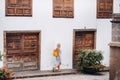 A blonde in a sundress with a backpack walks along the street of the Old town of Garachico on the island of Tenerife.Spain, Canary