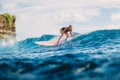 Blonde surf girl riding on surfboard in ocean during surfing. Surfer on blue wave Royalty Free Stock Photo