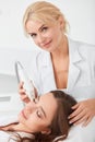 Blonde talented cosmetologist improving the face of client