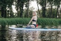 blonde tattooed girl sitting on paddle board