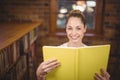 Blonde teacher reading book in the library Royalty Free Stock Photo