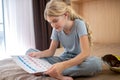 A blonde teen ,marking days of her periods in a calendar