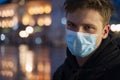 Blonde teen wearing surgical mask over his face