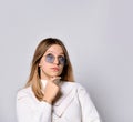 Blonde teenager in sunglasses, smart watch, bracelet and sweater. She is looking thoughtful, posing isolated on white. Close up Royalty Free Stock Photo