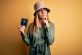 Blonde tourist woman with blue eyes on vacation holding australian passport using binoculars serious face thinking about question,
