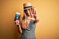 Blonde tourist woman with blue eyes on vacation holding united states passport with dollars with open hand doing stop sign with Royalty Free Stock Photo