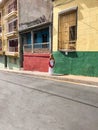 Blonde travels in the street with colored houses in Santiago de Cuba