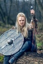 Blonde viking warrior woman in forest with shield and sword Royalty Free Stock Photo