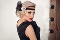 Blonde wavy hairstyle. Elegant woman portrait in retro style. Beautiful girl wears in vintage black dress and gloves. Hollywood
