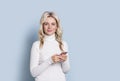 Blonde woman adult attractive beautiful portrait with cellphone, mobile, cauasian and scandinavian girl on blue background Royalty Free Stock Photo