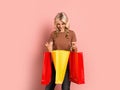 Blonde woman adult attractive beautiful smiling portrait, caucasian  girl with shopping bags on pink background Royalty Free Stock Photo