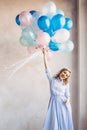 Blonde woman with balloons celebrates something