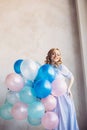 Blonde woman with balloons celebrates something