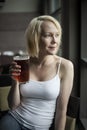 Blonde Woman with Beautiful Blue Eyes Drinking Glass of Pale Ale