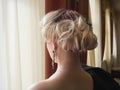 Blonde woman with beautiful hairstyle with hair detail accessory, closeup rear view.