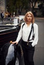 Blonde woman in black retro clothes near old vintage classic car Royalty Free Stock Photo