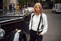 Blonde woman in black retro clothes near old vintage classic car Royalty Free Stock Photo