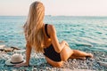 Blonde woman in black swimwear relaxing on sea. Royalty Free Stock Photo