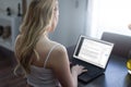 Blonde woman blogger writing on laptop at home blog