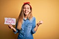 Blonde woman with blue eyes asking for girls rights holding banner with girl power message screaming proud and celebrating victory Royalty Free Stock Photo