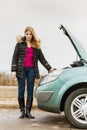 Blonde woman and broken down car on road Royalty Free Stock Photo