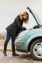 Blonde woman and broken down car on road Royalty Free Stock Photo