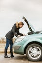 Blonde woman and broken down car on road Royalty Free Stock Photo