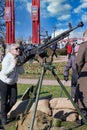 Blonde woman in dark glasses shoots an anti-aircraft machine gun aiming upwards Royalty Free Stock Photo
